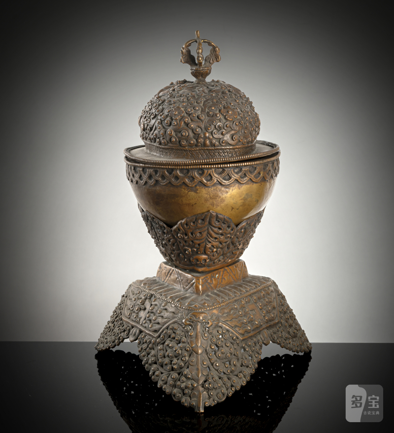 A COPPER EMBOSSED KAPALA WITH COVER ON STAND